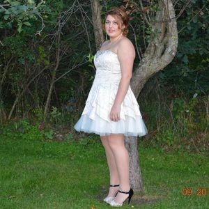 A cream colored homecoming dress with gold print.